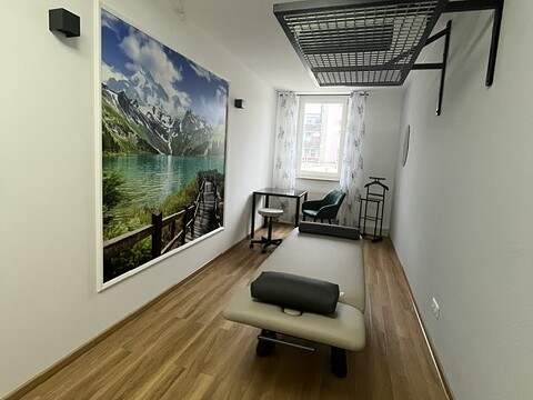 Behandlungsraum Berge mit Therapieliege, Schlingentisch und Bergmotiv