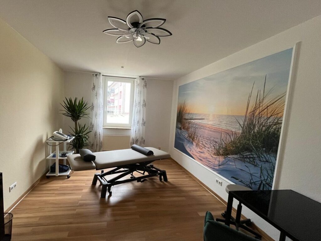 Behandlungsraum Meer mit Therapieliege und Strandmotiv